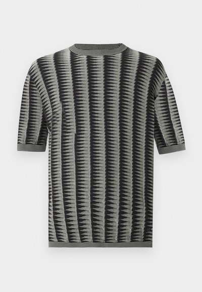 Haut en maille à manches courtes gris avec des rayures en zigzag noires. Doté d'un col rond côtelé et d'un tissu texturé à la finition lisse.