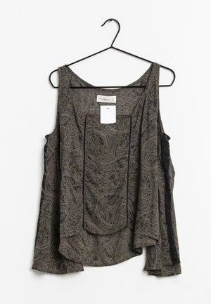 Blouse sans manches de couleur gris foncé avec un motif paisley, accents en dentelle noire sur les côtés, encolure ronde et une poche sur le devant. Accrochée à un crochet noir.