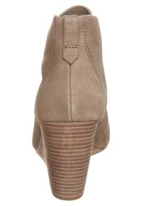 Stivale alla caviglia in pelle beige con una texture liscia, forma affusolata e tacco impilato con righe orizzontali. Anello posteriore per facilitare l'indossamento.
