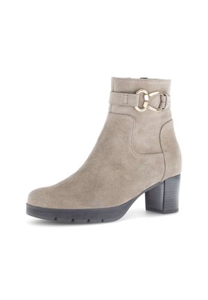 Beige suede ankle boot with black block heel and gold-tone decorative buckle strap around the upper shaft.
