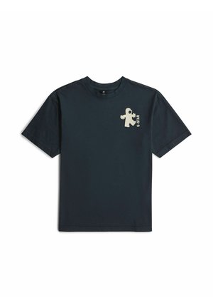 T-shirt noir à manches courtes avec un petit motif beige d’astronaute et le texte "G-STAR" sur la poitrine gauche.