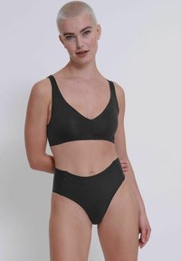 Schwarzes Bikini-Set aus zwei Teilen mit einem V-Ausschnitt-Bralette und hochgeschnittenen Hosen. Glatte Textur mit schlichten Design und ohne sichtbare Muster.