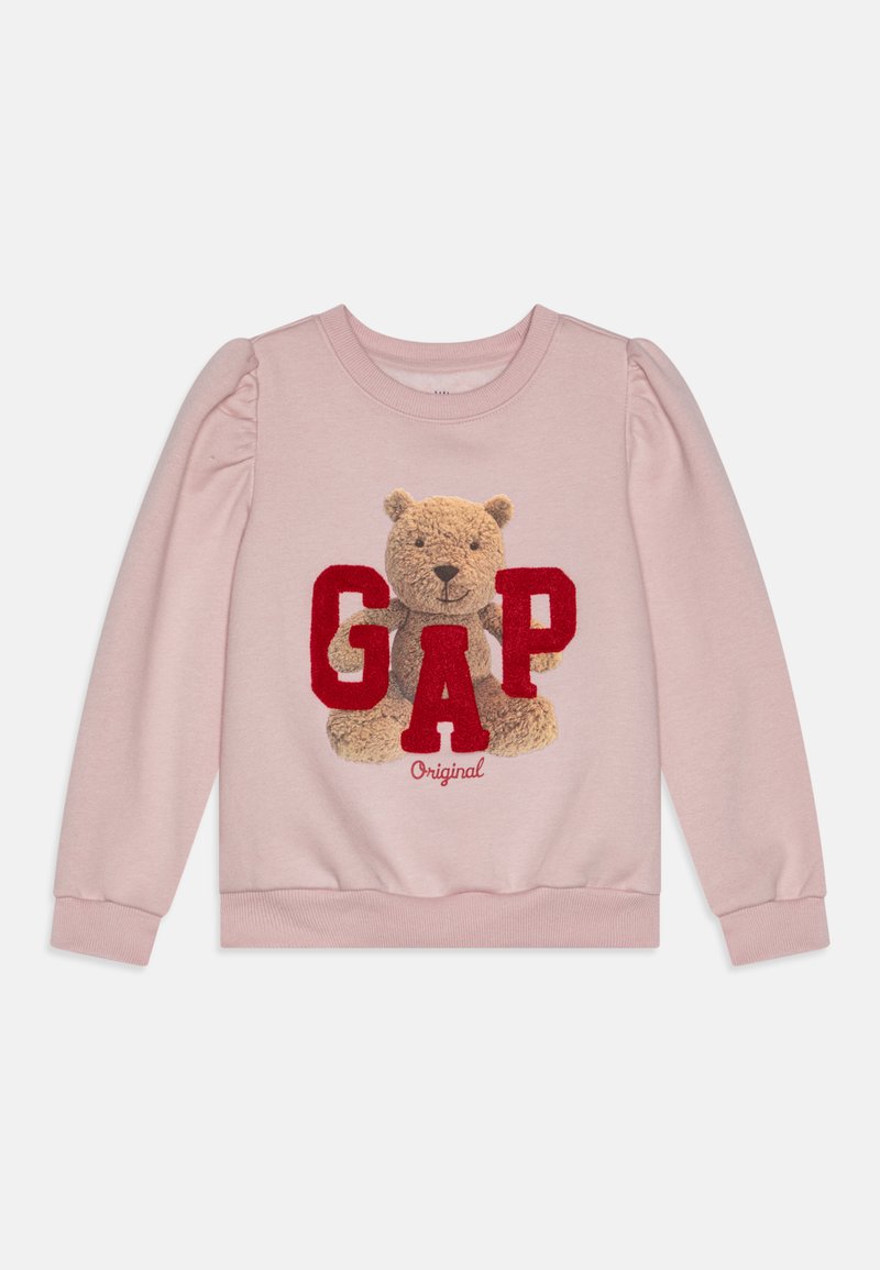 Šviesiai rožinė megzta palaidinė su pūkuotu meškinu grafiką ir ryškiai raudonu "GAP" užrašu. Puff rankovės ir banguotos rankogaliai užbaigia dizainą.