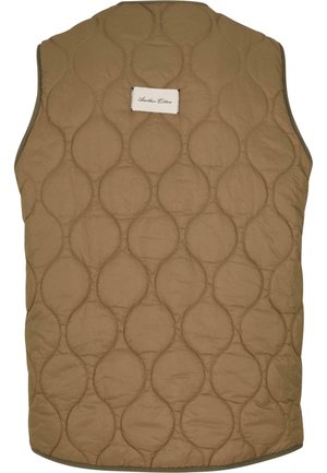 Quilted vest in tan fabric featuring circular patterns and a patch label. No sleeves with a rounded neckline and hemmed edges.