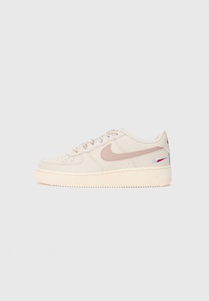 Kremfarvet Nike Air Force 1 sneaker med lavt snit, lyserød swoosh og farverig broderet swoosh nær hælen, på hvid baggrund.