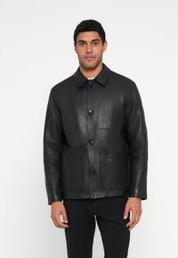 Schwarze Lederjacke mit einem Kragen, Frontknopfverschluss und zwei Brusttaschen. Glatte Textur und taillierte Passform.