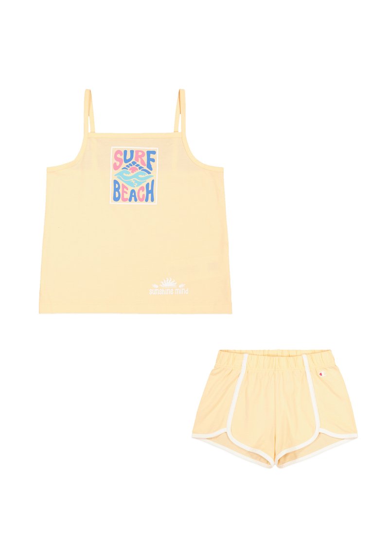 Camiseta amarilla sin mangas con la impresión "SURF BEACH", combinada con pantalones cortos amarillos a juego con detalles blancos y cinturilla elástica. Tejido liviano.