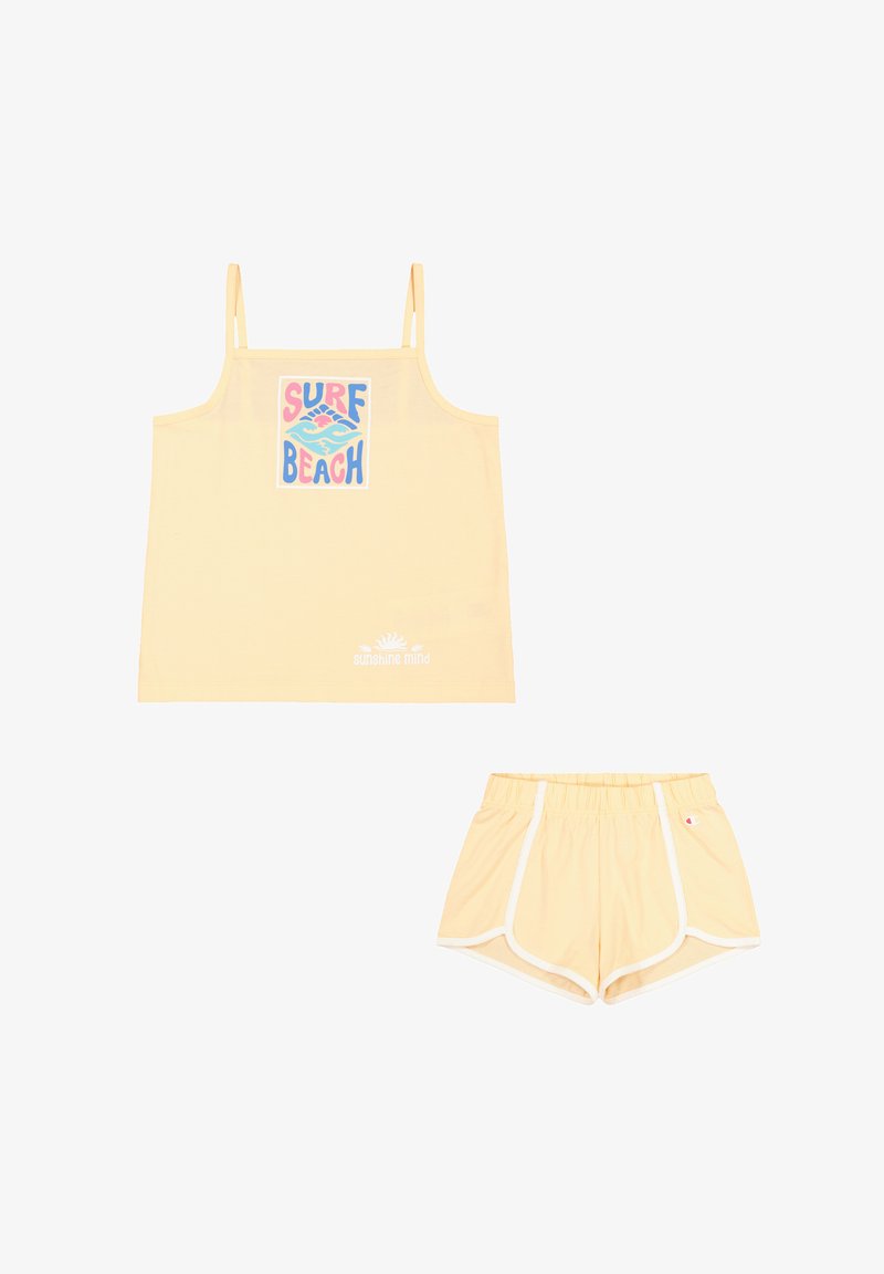 Camiseta amarilla sin mangas con la impresión "SURF BEACH", combinada con pantalones cortos amarillos a juego con detalles blancos y cinturilla elástica. Tejido liviano.