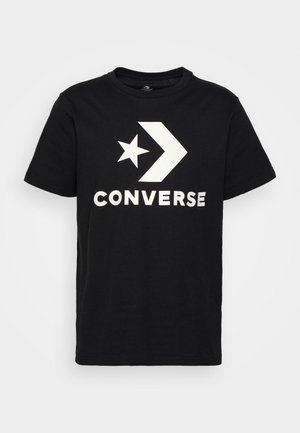 Camiseta de algodón negra con un gráfico blanco que presenta una estrella, una flecha y la palabra "CONVERSE" en letras mayúsculas y negritas. Manga corta y cuello redondo.