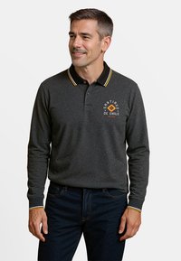Donkergrijze polo met lange mouwen en een zwarte kraag, voorzien van gele en witte strepen. "Santiago de Chile" logo op de borst.
