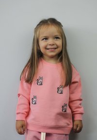 Roze sweatshirt met geborduurde kattenontwerpen. Zachte stof, lange mouwen, geribde manchetten en een relaxte pasvorm. Gecombineerd met bijpassende broek.