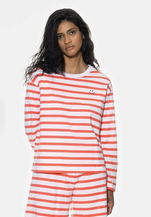 Long-sleeve pajama set with white and coral stripes. Features a smiley face detail on the chest. Made of soft, textured fabric.