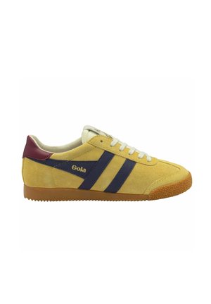 Gelbe Wildledersneaker mit marineblauen Streifen, weißen Schnürsenkeln und einer kastanienbraunen Fersenstütze. Strukturiere Gummisohle und Logodetail an der Seite.