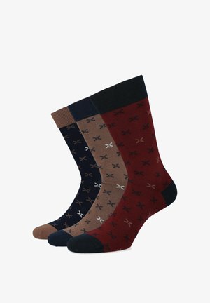 Trzy pary bawełnianych skarpetek w kolorach granatowym, brązowym i burgundowym z małym białym wzorem nożyczek, z prążkowanymi mankietami i wzmocnionymi piętami.