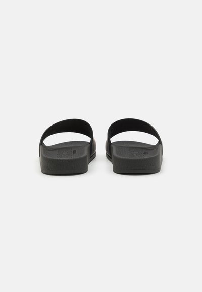 Schwarze Riemchensandalen mit zwei breiten Riemen, aus strukturiertem Material; flache Sohle mit leichter Polsterung und minimalistischem Design.