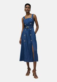 Vestido midi de mezclilla con escote cuadrado, tirantes gruesos, botones en la parte delantera, cintura ceñida con cinturón y una abertura lateral, en azul oscuro.