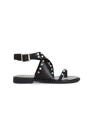 Sandalias planas de cuero negro con un diseño de tiras adornadas con tachuelas de varios colores, hebilla ajustable y suela plana con un acento dorado.