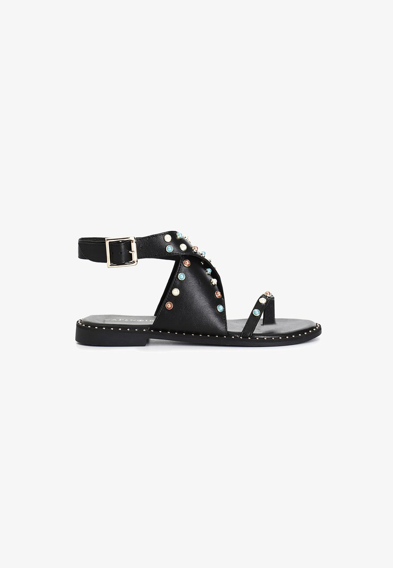 Sandale plate din piele neagră, cu un design cu curele decorative și studuri de diverse culori, cataramă ajustabilă și talpă plată cu un accent auriu.