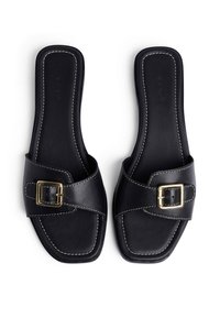 Sandalias deslizantes de cuero negro con punta cuadrada, que cuentan con una tira ancha y un acento de hebilla dorada. La costura en contraste añade detalle al diseño.