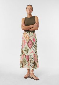 Maxirock mit einem floralen geometrischen Muster in Pink, Grün und Orange auf einem hellen Hintergrund, mit einem gestuften Design und einem elastischen Bund.