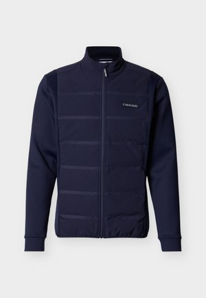 Giacca con zip blu navy con pannello frontale trapuntato, maniche lunghe, collo alto e piccolo logo Calvin Klein sul petto.