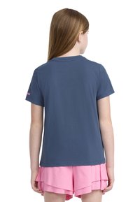 Tmavě modré bavlněné tričko s kulatým výstřihem a krátkými rukávy. Na levém rukávu je umístěno růžové logo. Tričko je zkombinováno s světle růžovými vrstvenými šortkami.