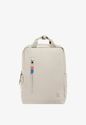 Mochila gris claro con una tela suave, que cuenta con un bolsillo frontal con cremallera, acentos de tirador de cremallera de color y un logo en el lado.