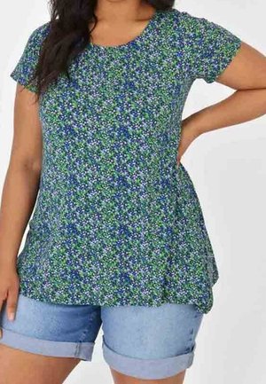 Top de manga corta con estampado floral en verde y azul, con cuello redondo y dobladillo acampanado, combinado con pantalones cortos de mezclilla claros. Textura de tela suave.