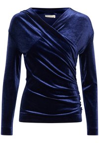 Top lungo manica in velluto blu navy con design avvolgente, caratterizzato da una texture raccolta e una scollatura a V profonda. Tessuto morbido e liscio con una leggera lucentezza.