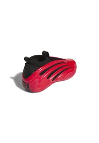 Sneaker rossa con parte superiore in tessuto nero caratterizzata da un design adonde sovrapposte, suola in gomma prominente e tasselli per una facile vestibilità.