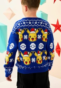 Niebieski sweter dziewiarski z motywem twarzy Pikachu w czapkach Mikołaja, płatków śniegu oraz wzorów geometrycznych. Ribbowane mankiety i dół.