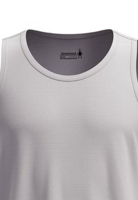 Helles graues Tank-Top mit strukturiertem Muster, rundem Halsausschnitt und minimalen Nähten. Etikett sichtbar, das Marke und Größe angibt.