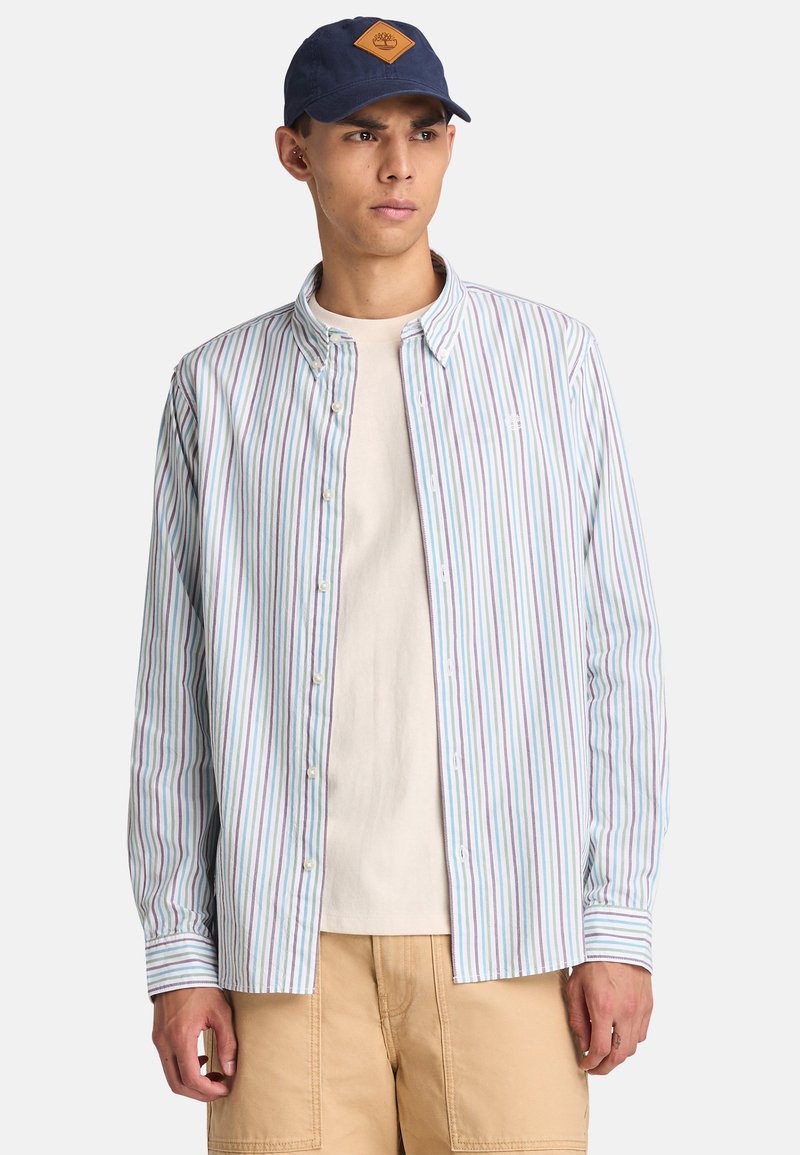 Langermig shirt met verticale paarse, blauwe en groene strepen, gemaakt van lichte stof. Voorzien van een knoopsluiting en een puntenkraag.