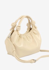 Petit sac à main couleur crème avec anses doubles nouées, haut froncé et bandoulière ajustable avec boucle argentée.