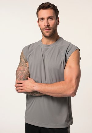 Haut de sport sans manches gris en tissu lisse, avec un col rond et une coupe décontractée, présentant des coutures visibles et un logo à l'ourlet.