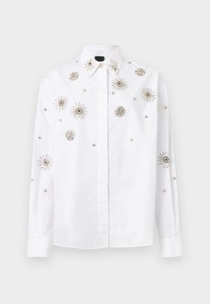 Camisa blanca de manga larga con botones, adornada con motivos florales de joyas plateadas dispersas por el frente, las mangas y el cuello.