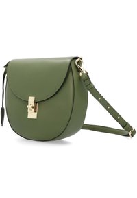 Grüne Leder-Crossbody-Tasche mit runder Form, goldenen Beschlägen, Klappenverschluss und verstellbarem Tragegurt mit Nieten-Details.