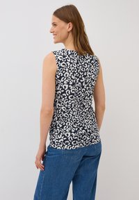 Top senza maniche di colore blu navy con un design a stampa leopardo bianco, realizzato in tessuto morbido, con scollo rotondo e vestibilità rilassata.