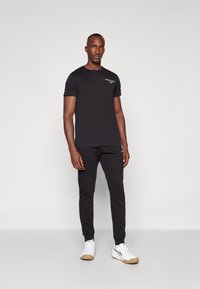Björn Borg ESSENTIAL PANTS - Treniņtērpa apakšdaļas - black beauty