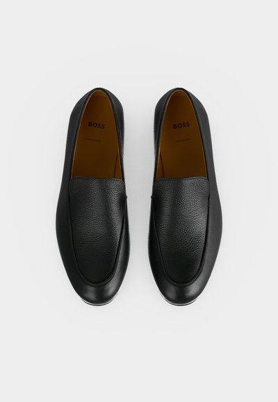 Paire de chaussures noires en cuir à enfiler avec bouts arrondis et semelles intérieures marron clair estampillées, vues de dessus sur fond blanc.