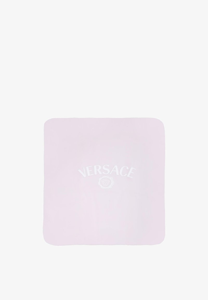 Couverture en coton rose avec un logo et un emblème "Versace" blancs au centre. Forme carrée avec des coins arrondis, texture lisse.