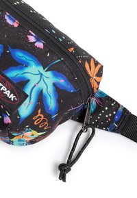 Černá ledvinka s barevnými květinovými a listovými vzory, vyrobená z odolné látky. Obsahuje zipové uzavření a nastavitelné popruhy.