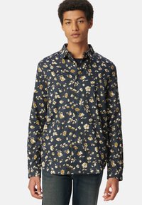 Camicia floreale blu navy con piccoli fiori bianchi e dorati, design con bottoni, maniche lunghe e colletto classico. Tessuto leggero.