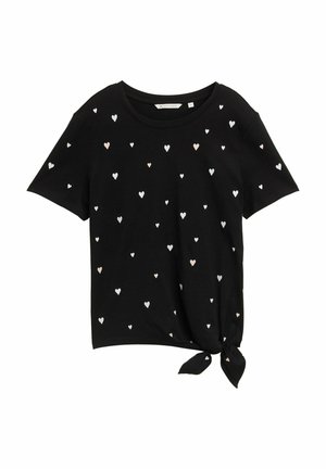 Zwarte T-shirt met korte mouwen, bedekt met verspreide hartjespatronen in wit en lichtroze, met een gestrikte knoopdetail aan de onderrand.