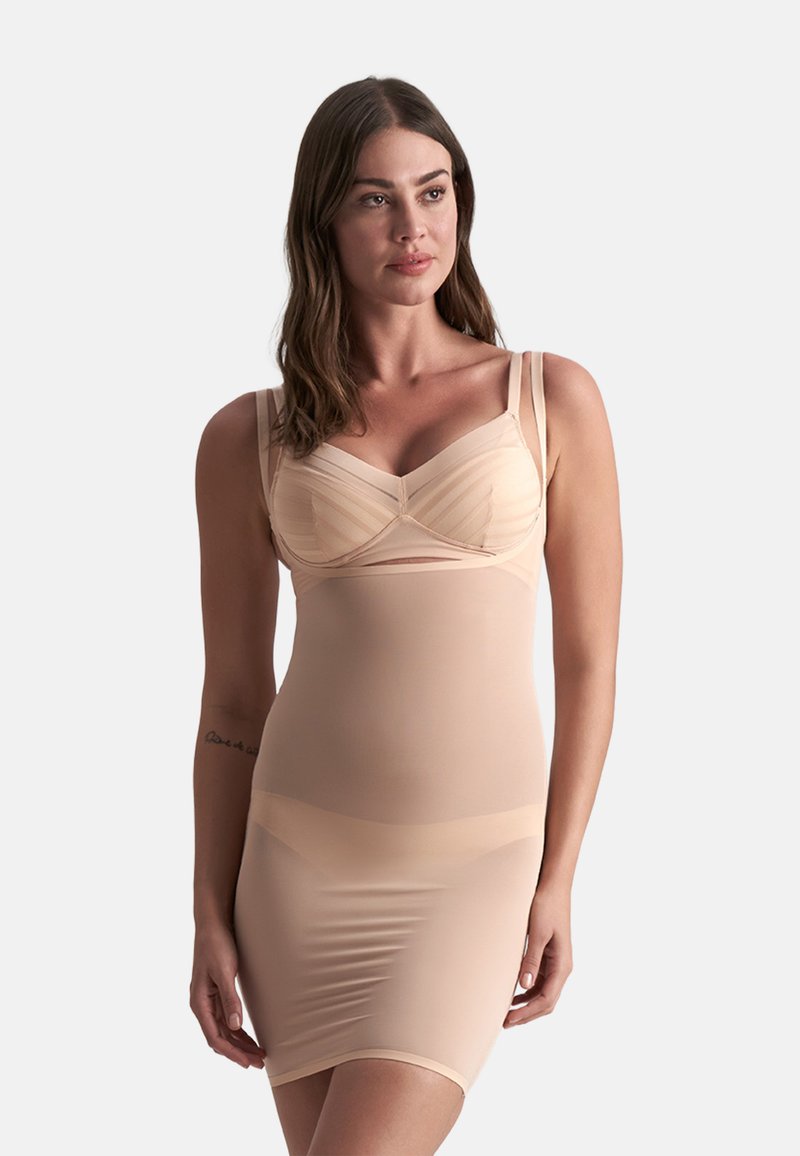 Combinazione di abito beige modellante e reggiseno, caratterizzata da un tessuto morbido, una superficie liscia, spalline regolabili e un design aderente per un supporto ottimale.
