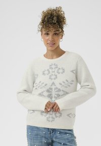 Pull gris clair avec un motif texturé et pailleté blanc, et un col rond. Il possède des manches longues et des poignets légèrement côtelés.