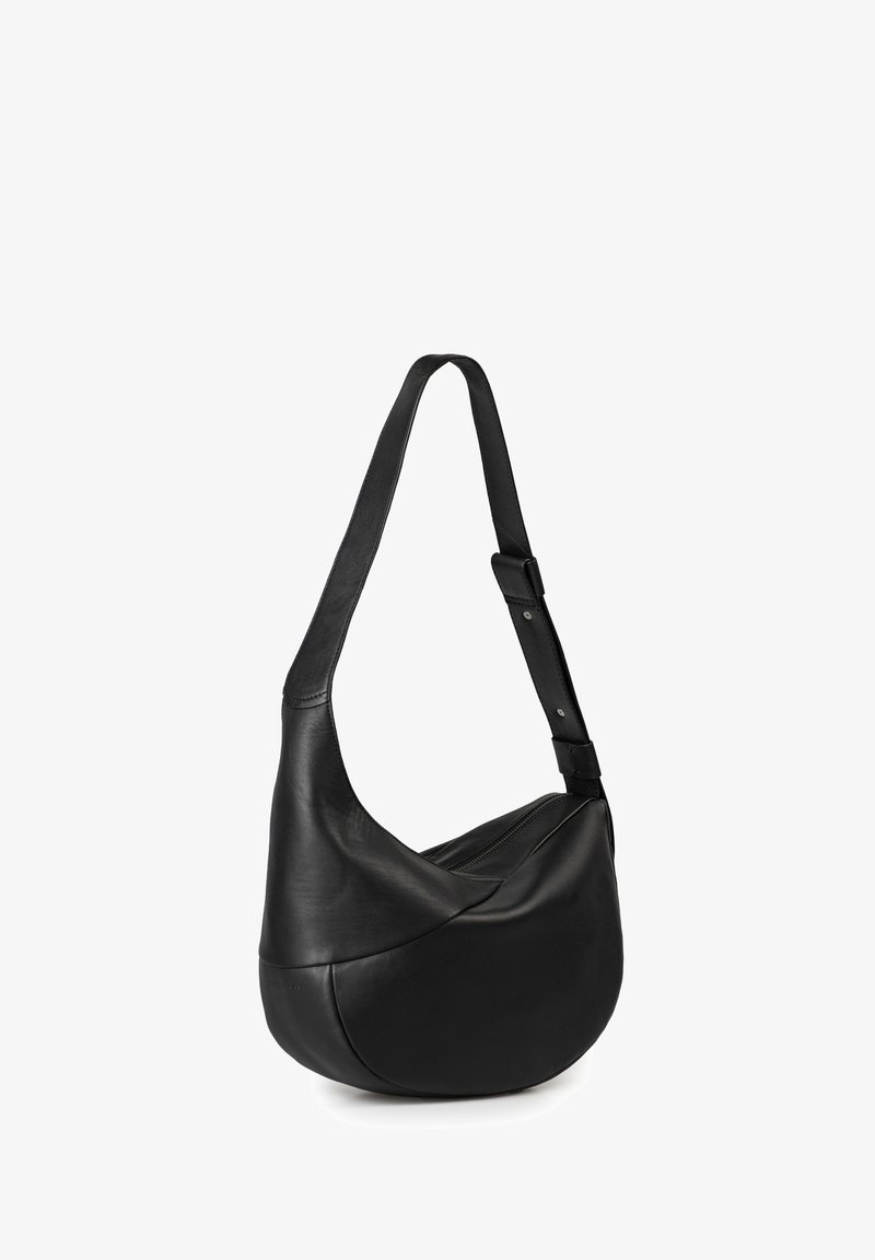 Borsa a spalla in pelle nera con design curvo, tracolla regolabile e chiusura con zip superiore. Texture liscia e senza dettagli hardware visibili.