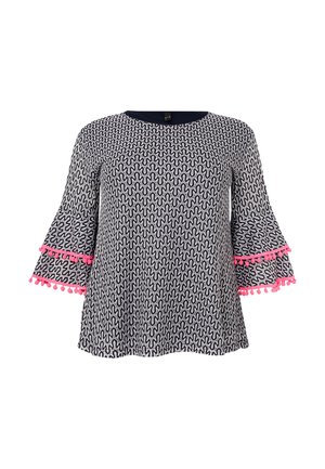 Zwart-witte top met een golvend patroon, ronde hals en uitlopende mouwen met roze pomponaccenten langs de manchetten.