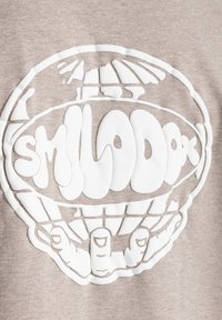 Beige sweatshirt med et stort hvidt grafisk design af en globe med hænder, detaljeret med glat tekstur og runde former.