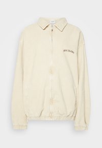 Krémový kordový kabát s předním zipem, límcem, elastickými manžetami a vyšitým nápisem BDG JEANS na levé straně.